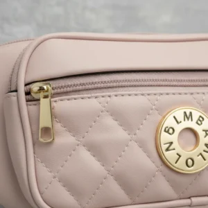 Detalle de cierre dorado y textura acolchada cartera rosa