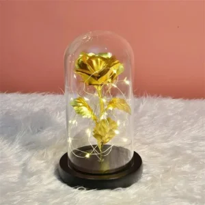 Rosa eterna dorada con luces LED dentro de cúpula de cristal sobre base de madera