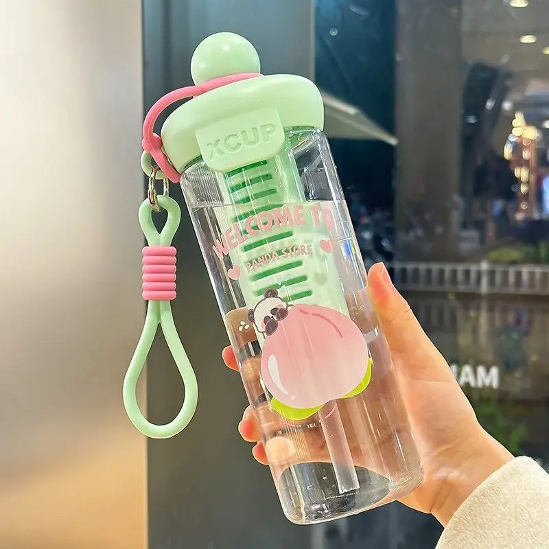 Termo cooler verde con infusor de sabores, diseño panda y colgante de silicón sostenido en mano