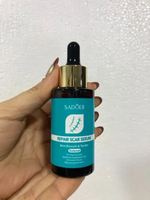 serum Mano sosteniendo el frasco del serum reparador de cicatrices Sadoer con gotero dorado